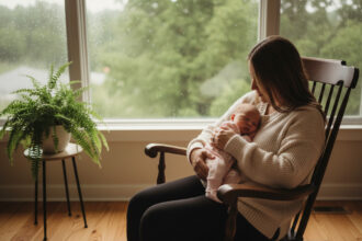 Bébé fille endormie dans les bras de sa mère dans un cadre chaleureux