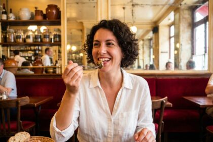 Jeune femme dégustant des escargots dans un bistrot parisien