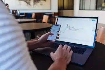 person using smartphone and MacBook Pro