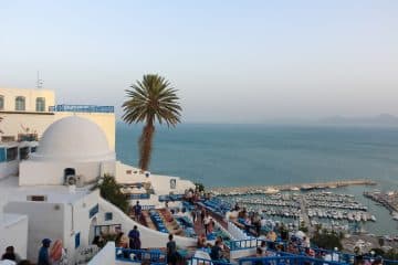 people on beach near white concrete building during daytime