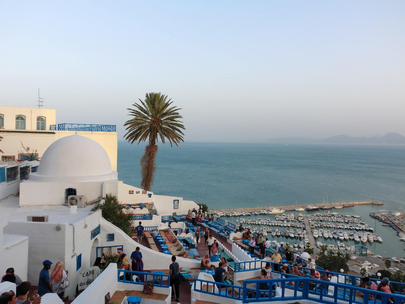 people on beach near white concrete building during daytime